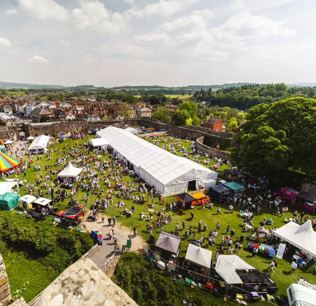 Ariel shot showing the ludlow spring festival at the castle with lots of tents and people